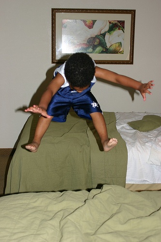 boy is jumping on bed
